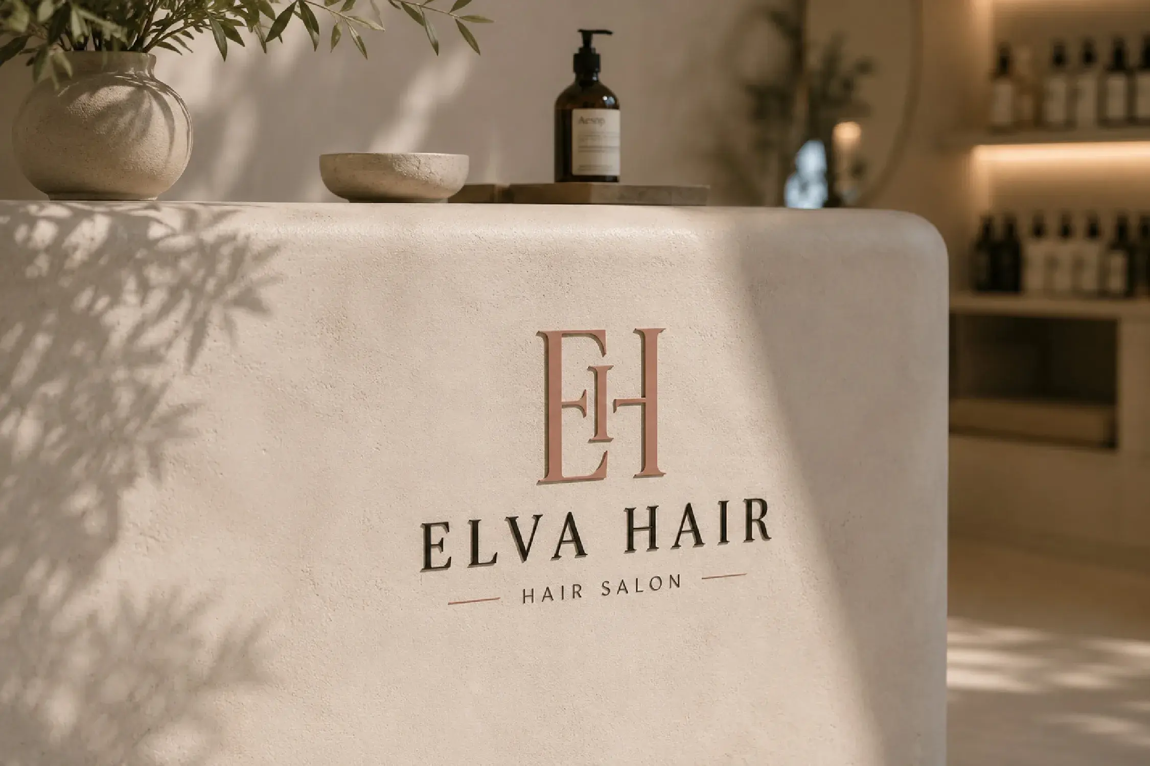 ELVA Hair salon reception mockup with monogram and wordmark on a warm textured counter.