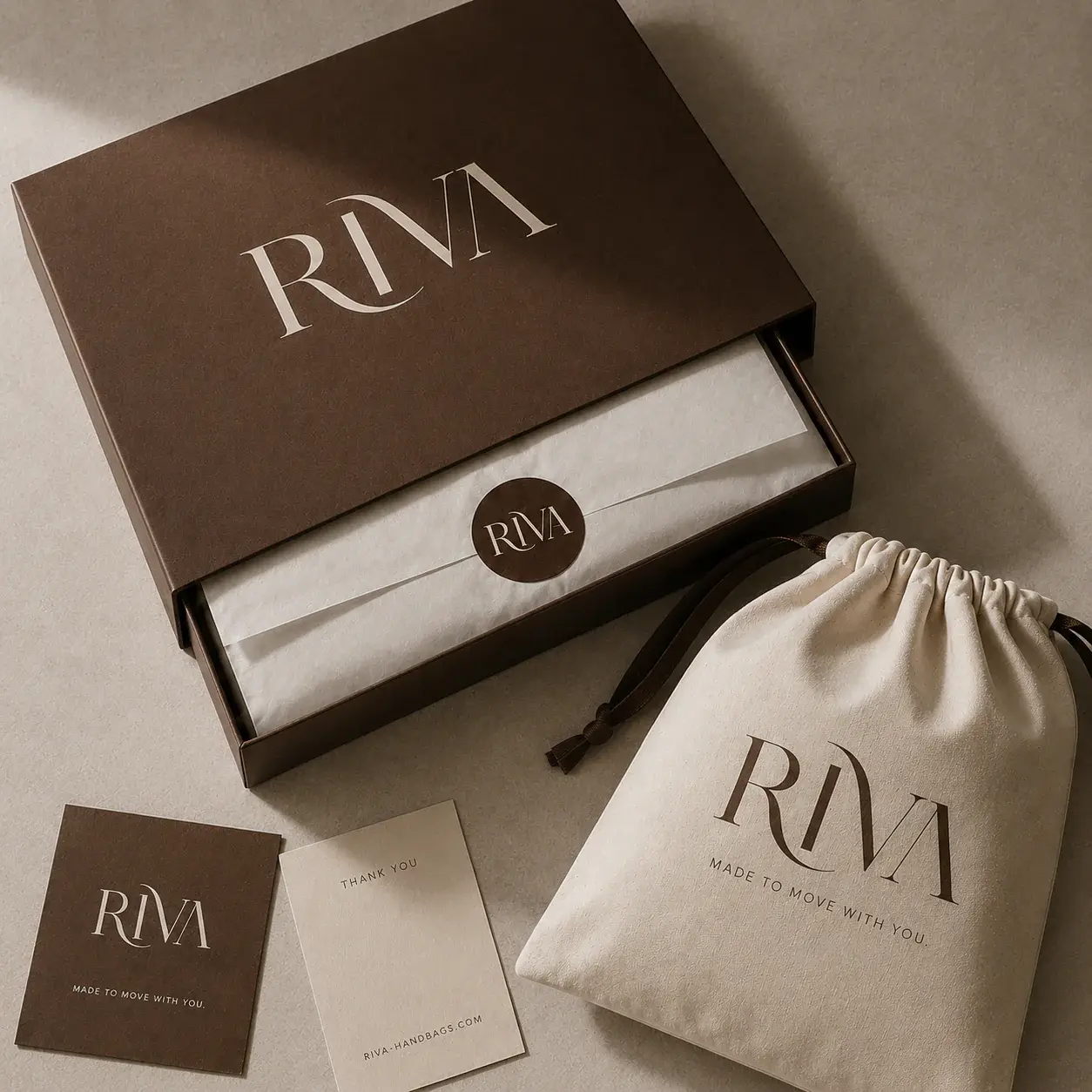 Open RIVA handbag box with tissue, dust bag, thank-you card and branded insert.