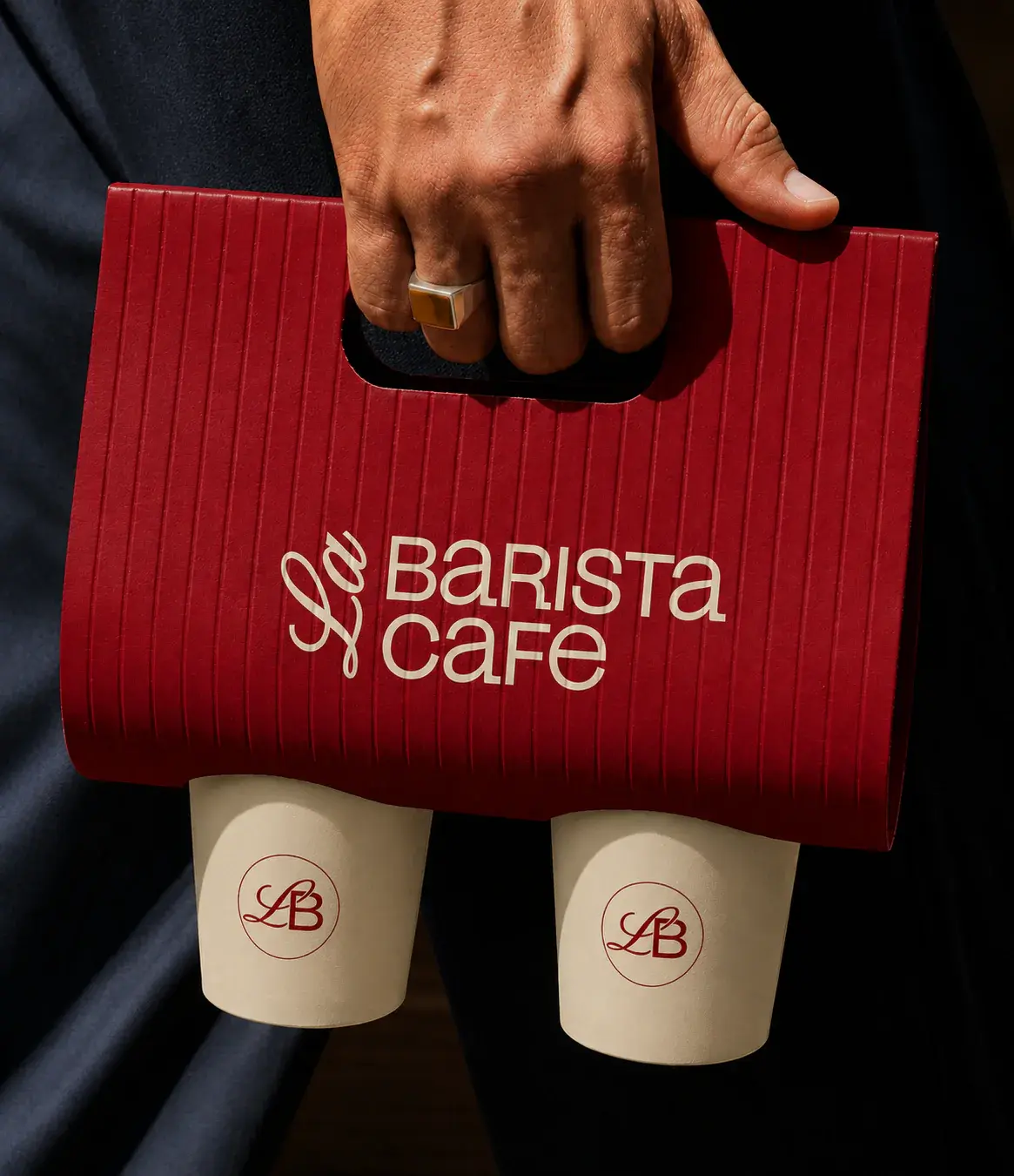 Red La Barista Cafe takeaway carrier with two branded cream coffee cups.